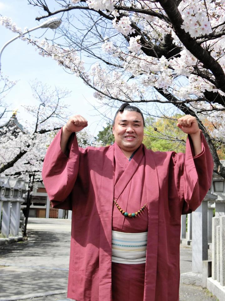 　初優勝から一夜明け、桜の下でガッツポーズする霧馬山