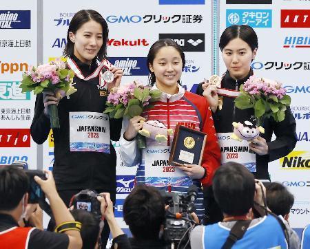 　女子２００メートル個人メドレーで優勝し、メダルを掲げる成田実生（中央）。左は２位の大橋悠依、右は３位の松本信歩＝東京アクアティクスセンター