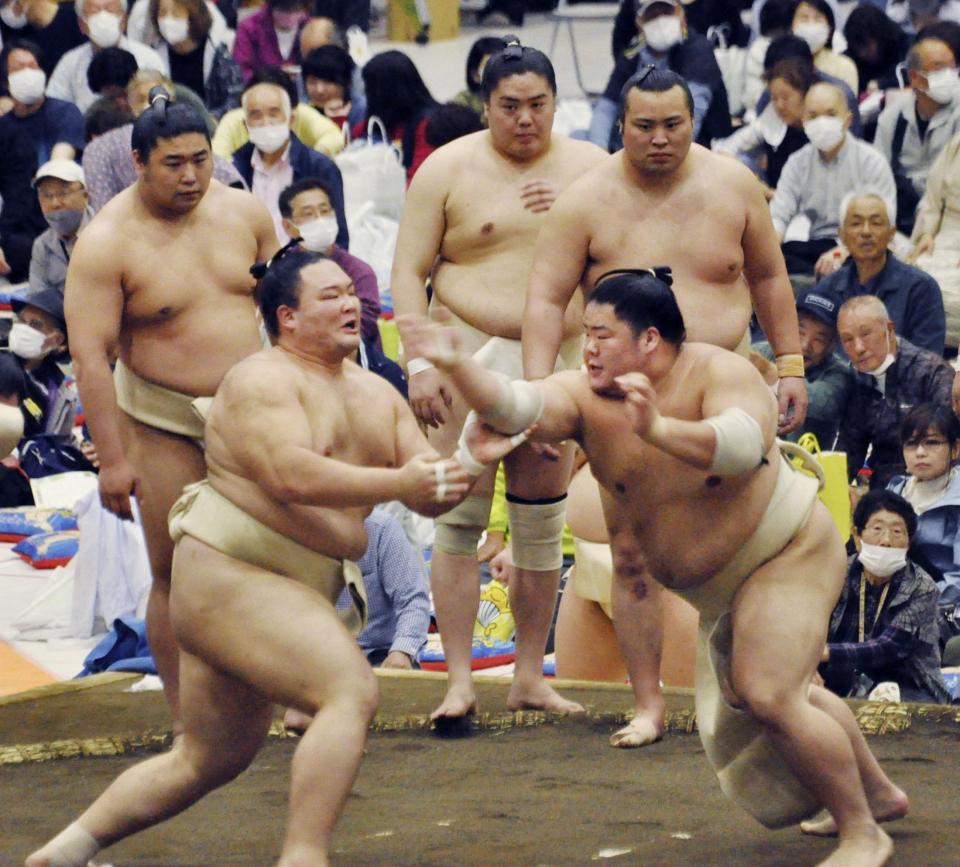 　春巡業で大栄翔（手前右）と相撲を取る朝乃山