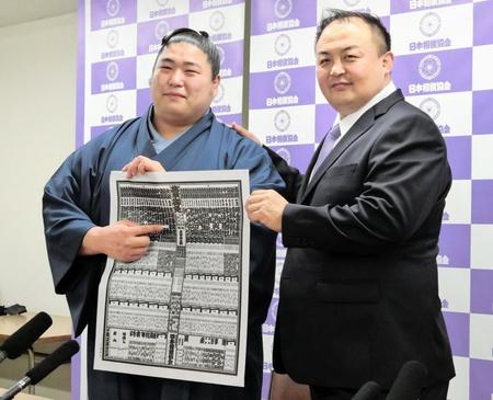 　新関脇に昇進した若元春（左）は、師匠の荒汐親方と番付表を手にポーズをとる
