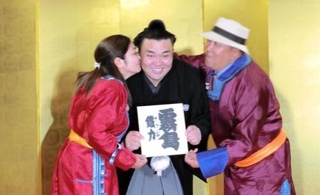 　大関昇進が決まった霧馬山（中央）は、母・エンフゲレルさん（左）から祝福のキスを受ける。右は父・ビャンブチュルンさん