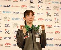 　世界選手権からの帰国会見で２種目のメダルを掲げる早田ひな