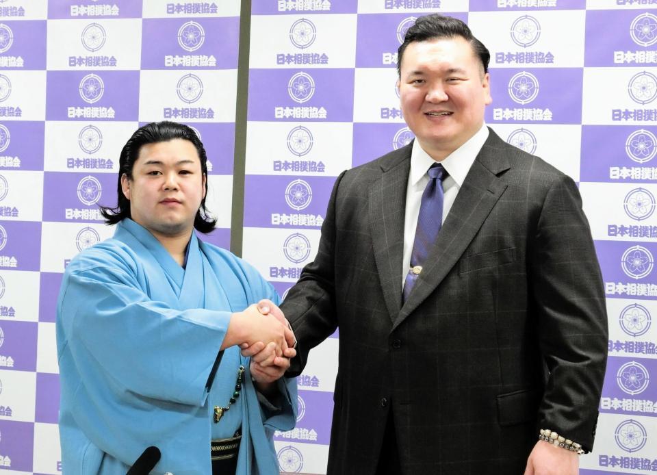 　新十両昇進が決まった川副改め輝鵬（左）は、師匠の宮城野親方と握手する
