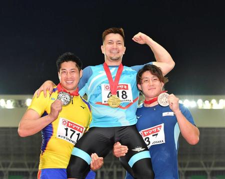 　男子やり投げで優勝したディーン元気（中央）は新井（左）と崎山に担がれ笑顔を見せる