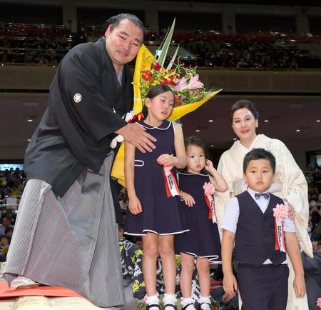 　妻のダシニャム・ムンフザヤさん（右奥）、（手前右から）長男のアナンダ・アマルバヤスガラン君、次女のアナンダ・エネルレンちゃん、長女のアナンダ・アニルランちゃんから花束を贈られた鶴竜親方（撮影・吉澤敬太）