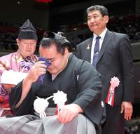 　父のチメドウ・マンガラジャラブさん（右）にはさみを入れてもらい涙する鶴竜親方（撮影・吉澤敬太）