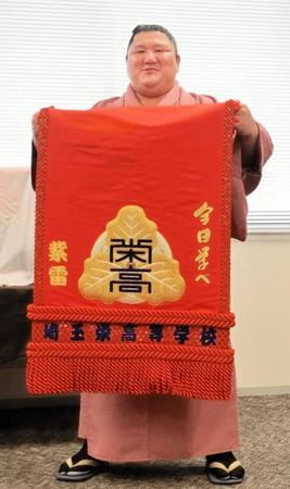 　母校・埼玉栄高から贈呈された化粧まわしを笑顔で披露する紫雷