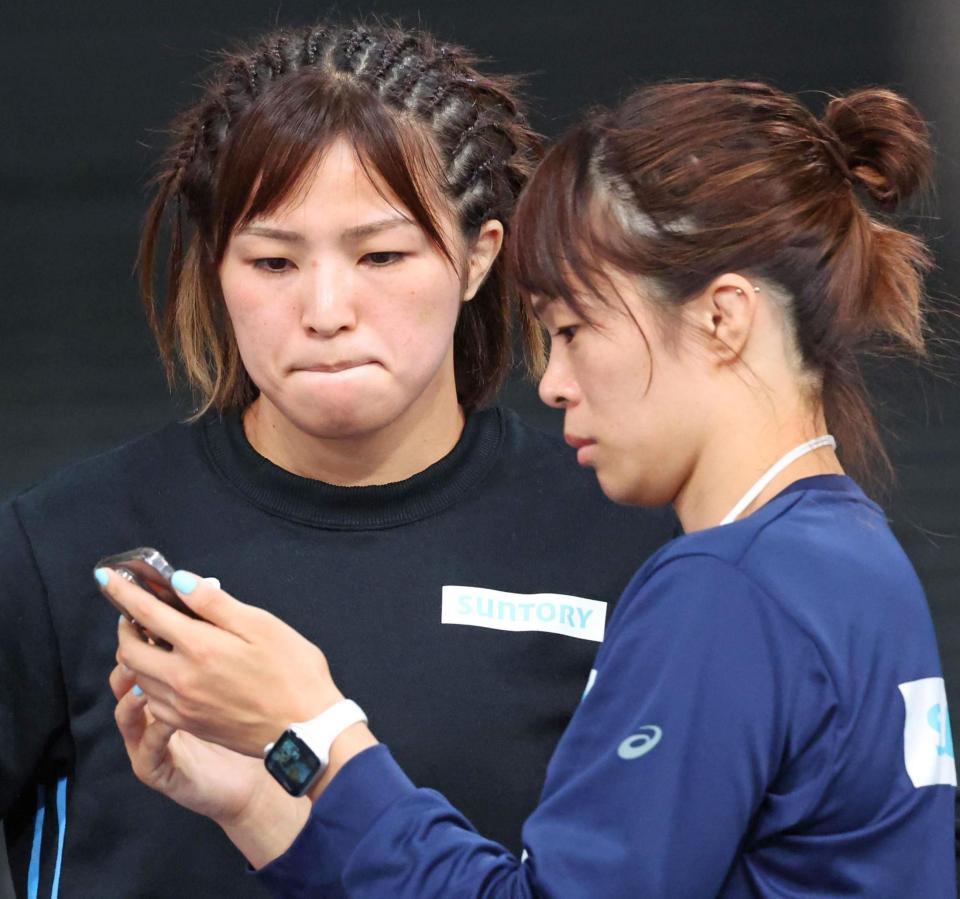 　試合前、スマホを見ながら姉の金城梨紗子（右）の話を聞く川井友香子（撮影・吉澤敬太）