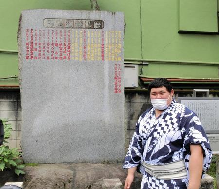 　歴代横綱のしこ名が刻まれた石碑の前に立つ大の里