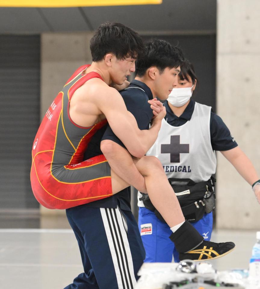 　準決勝で右足を痛め、試合後、背負われながら治療へ向かう乙黒拓斗（撮影・伊藤笙子）