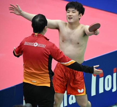 　優勝を決め、コーチと抱き合う張本智和
