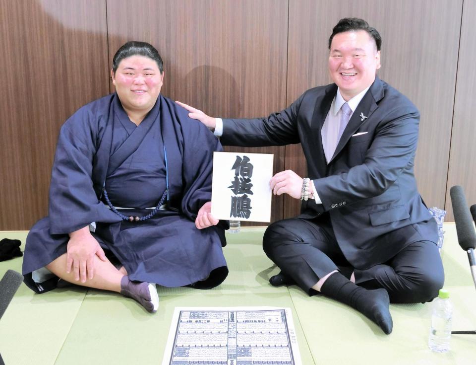 　しこ名の書かれた色紙を手に、笑みを浮かべる落合改め伯桜鵬（左）と宮城野親方