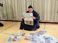 自身の優勝を報じる新聞を読む豊昇龍