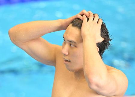　男子１００メートル自由形予選を終え、頭を抱えながら引き揚げる松元克央（撮影・中田匡峻）