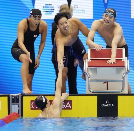 　混合４００メートルメドレーリレー決勝　最終泳者の池江璃花子（下）を迎える（左から）相馬あい、渡辺一平、入江陵介＝マリンメッセ福岡