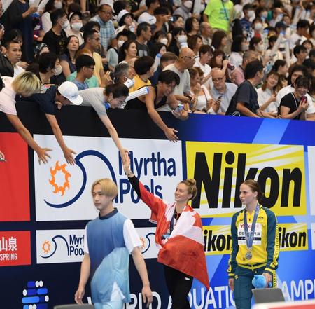 　女子２００メートルバタフライ決勝で金メダルを獲得したサマー・マッキントッシュ（中央下）はスタンドのファンと握手をする（撮影・中田匡峻）