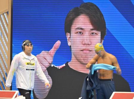 　男子１００メートルバタフライ準決勝、モニターでサムアップポーズを見せる松元克央（手前左）＝撮影・中田匡峻