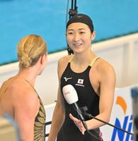 　女子５０メートルバタフライ予選を終え、他国の選手と言葉を交わし引き揚げる池江璃花子（撮影・中田匡峻）