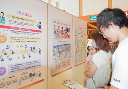 　２０３０年冬季五輪・パラリンピックの札幌開催の意義などを伝えるパネルを見る来場者＝２９日午前、札幌市