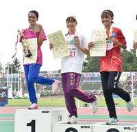 　女子１００メートルで優勝し、表彰台で笑顔でポーズをとる山形愛羽（左）＝撮影・中島達哉