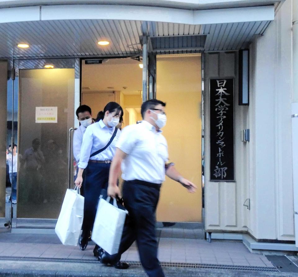 　日大アメフト部寮の家宅捜索を終え、押収品とみられる紙袋を手にして出てきた捜査官