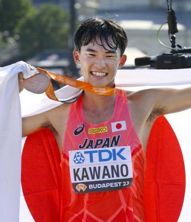 　陸上の世界選手権男子３５キロ競歩で銅メダルを獲得し、日の丸を掲げる川野将虎。今大会の日本勢のメダル第１号となった＝２４日、ブダペスト（共同）