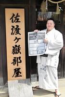 　新関脇に昇進し、部屋の看板の前で番付表のしこ名を指さす琴ノ若