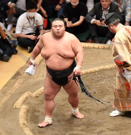 　分厚い懸賞を手に引き揚げる貴景勝（撮影・開出牧）