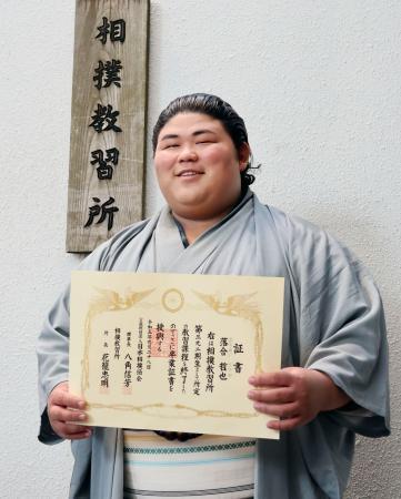 　相撲教習所の卒業証書を手に撮影に応じる伯桜鵬＝２８日、東京・両国国技館
