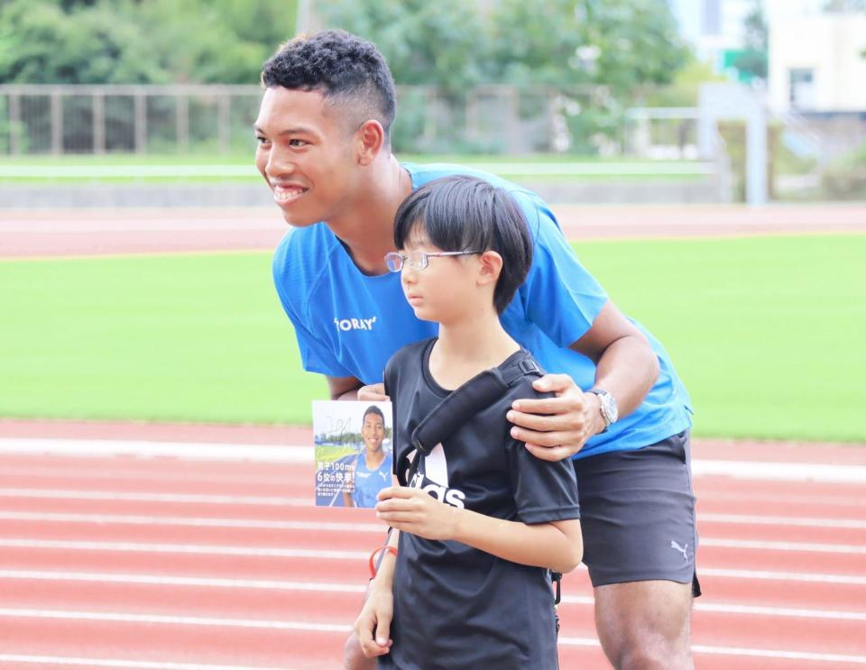 　イベントに参加した小学生と写真撮影を行うサニブラウン（左）