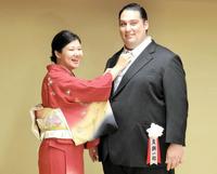 　整髪を終え、浩子夫人（左）にネクタイを直してもらう元関脇魁聖の友綱親方