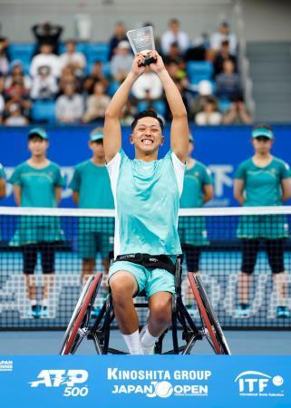 　車いすの部シングルスで優勝し、表彰式でトロフィーを掲げる小田凱人＝有明テニスの森公園