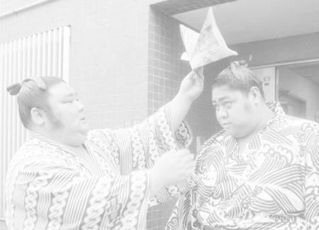 　三役に返り咲いた小錦（右）に紙のかぶとをかぶせる朝潮＝８５年４月