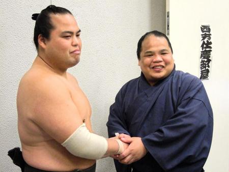 　現役最後の相撲を終えて弟の爆羅騎（ばらき）と握手する羅王（左）