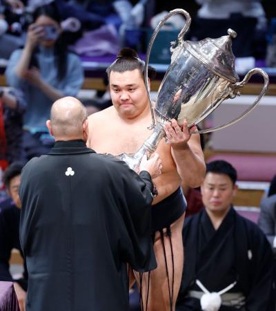 　大相撲九州場所で優勝を果たし、日本相撲協会の八角理事長（手前）から賜杯を受け取る霧島＝２６日、福岡市の福岡国際センター