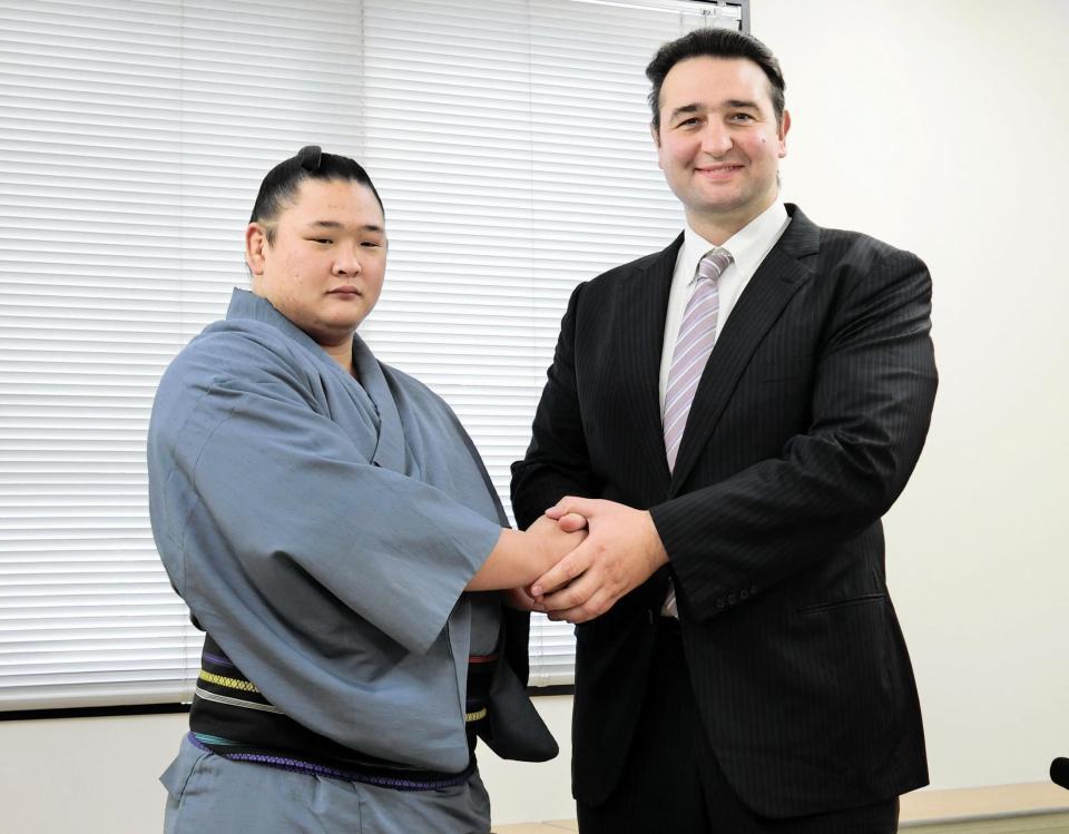 　新十両昇進が決まり、師匠の鳴戸親方（右）と握手する欧勝海