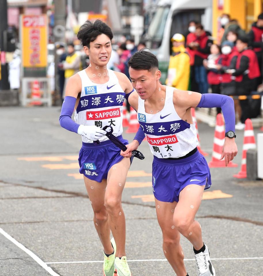 　３区の佐藤圭汰（手前）にたすきを渡す２区の駒大・鈴木芽吹（撮影・開出牧）