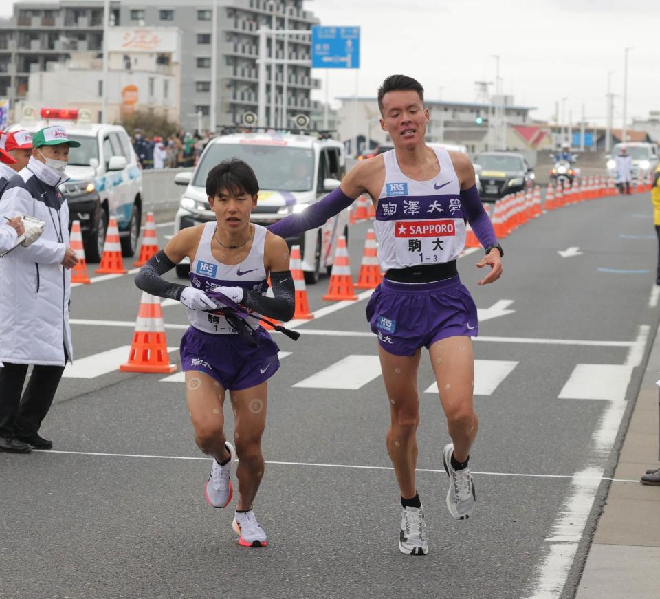 　平塚中継所２位でタスキをつなぐ駒大３区の佐藤圭汰（右）と４区の山川拓馬＝代表撮影