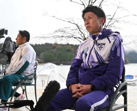 　往路ゴール後、インタビューを受ける駒大の藤田監督。左奥は青学大の原監督