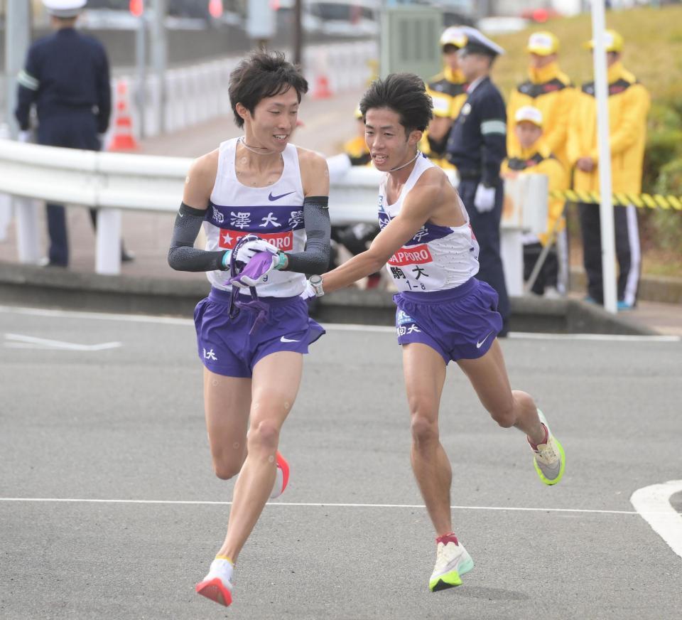 　襷を渡す駒大・赤星雄斗。左は花尾恭輔（撮影・堀内翔）