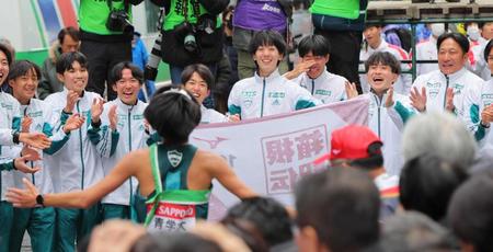 　ゴールしたアンカー・宇田川（手前）を笑顔で迎える青学大メンバーと原監督（右端）