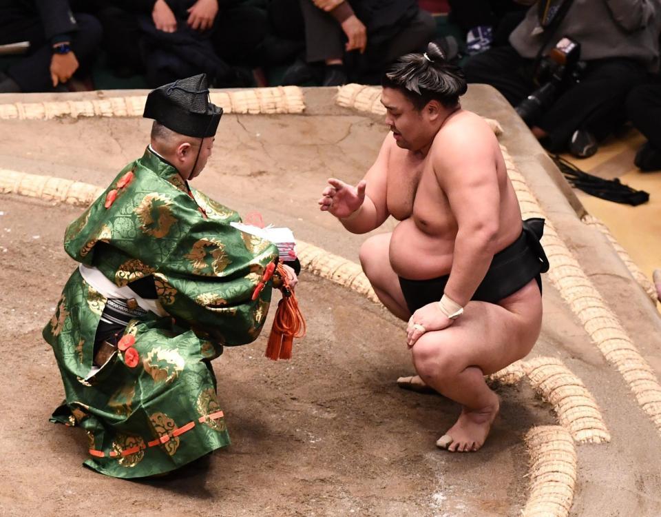 　行司の木村容堂（左）から懸賞金を渡される霧島＝撮影・園田高夫