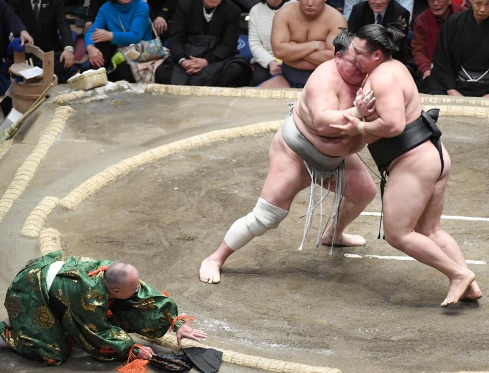 　霧島対北勝富士の取り組みで転倒する行司の木村容堂（左）＝撮影・棚橋慶太