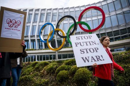 　国際オリンピック委員会本部の前でロシアとベラルーシ選手の中立での参加判断に抗議するウクライナ支援団体のメンバーら＝２０２３年３月、ローザンヌ（Ｋｅｙｓｔｏｎｅ提供・ＡＰ＝共同）