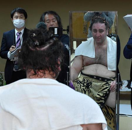 　断髪式を終え鏡でまげのない姿をみつめる栃ノ心（撮影・持木克友）