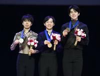　男子の表彰式でメダルを手に笑顔の優勝した鍵山優真（中央）と２位の佐藤駿（左）
