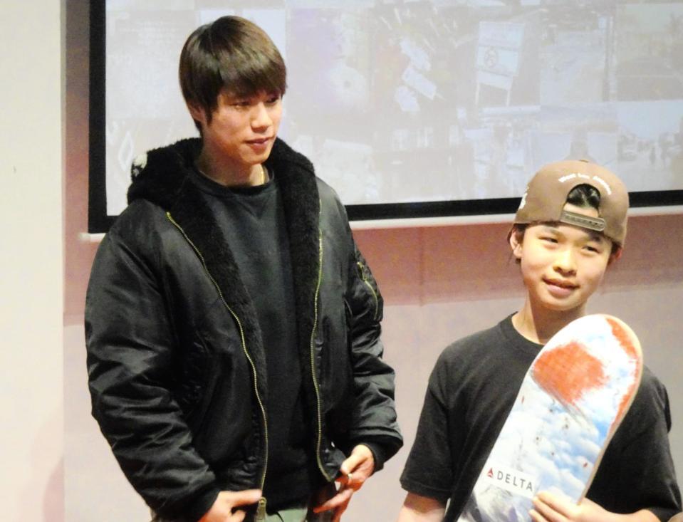 　イベントで抽選に当たった小学生の輪島琉生斗くんに自身のデッキをプレゼントする堀米雄斗（左）＝１６日