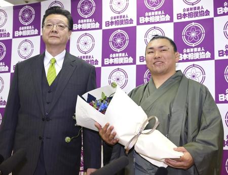 　花束を手に晴れやかな表情の照強。左は師匠の伊勢ケ浜親方