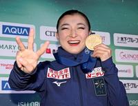 　フィギュアスケート世界選手権の女子で３連覇を果たし、笑顔で撮影に応じる坂本花織