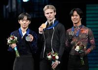 　２位となり、メダルを掲げる鍵山優真（左）。中央は優勝したイリア・マリニン